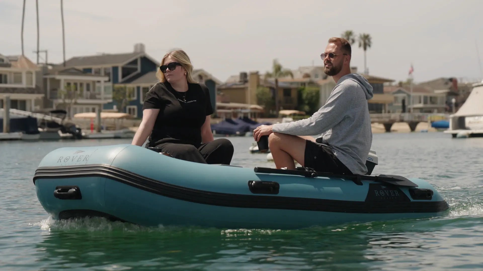 Two people riding customized inflatable dinghy on water