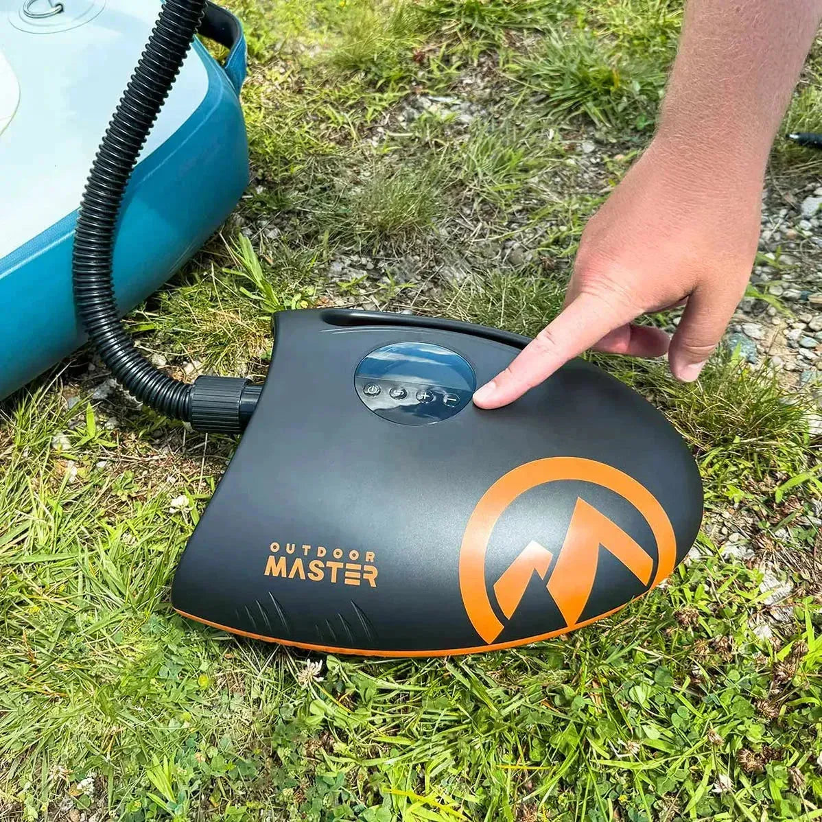 Outdoor Master Shark II electric pump being used to inflate a paddleboard, showing the digital pressure control and compact design.