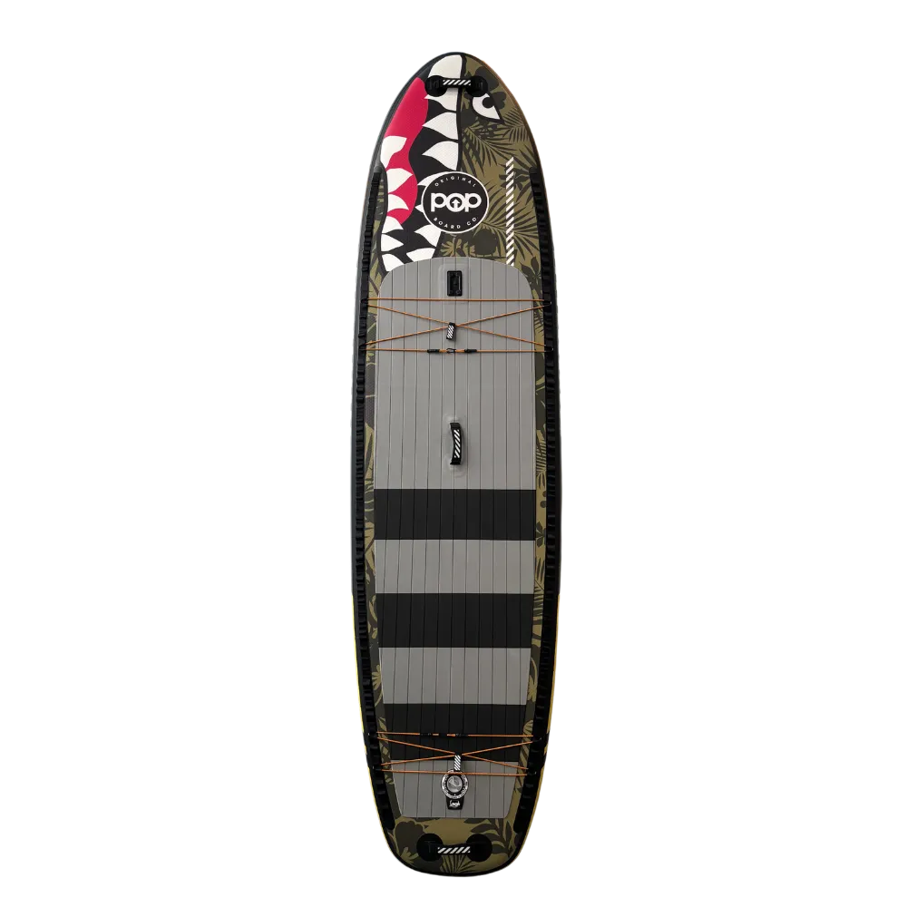 Top view of the 11'6" El Capitan Bomber inflatable paddleboard, featuring the signature shark mouth nose graphic, green camo print, and grey non-slip deck pad with black stripes.