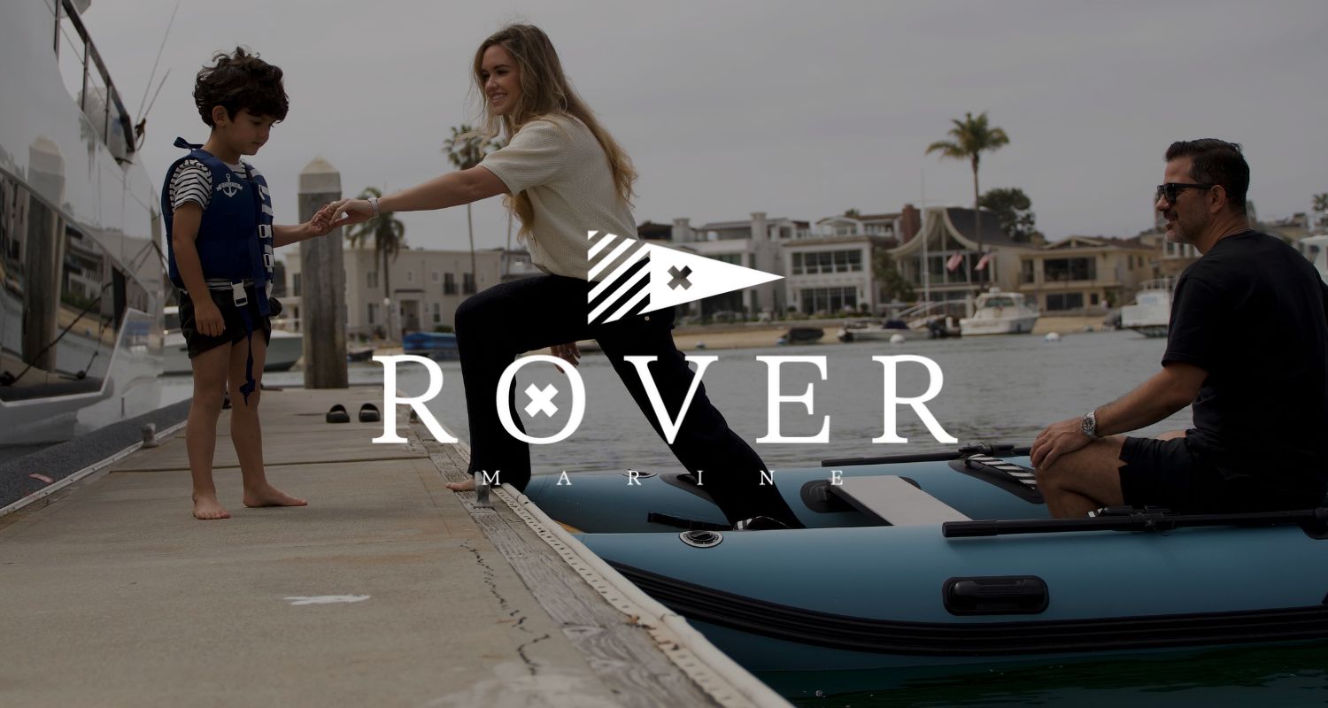 Person stepping from dock onto Rover Marine Battle Boat inflatable
